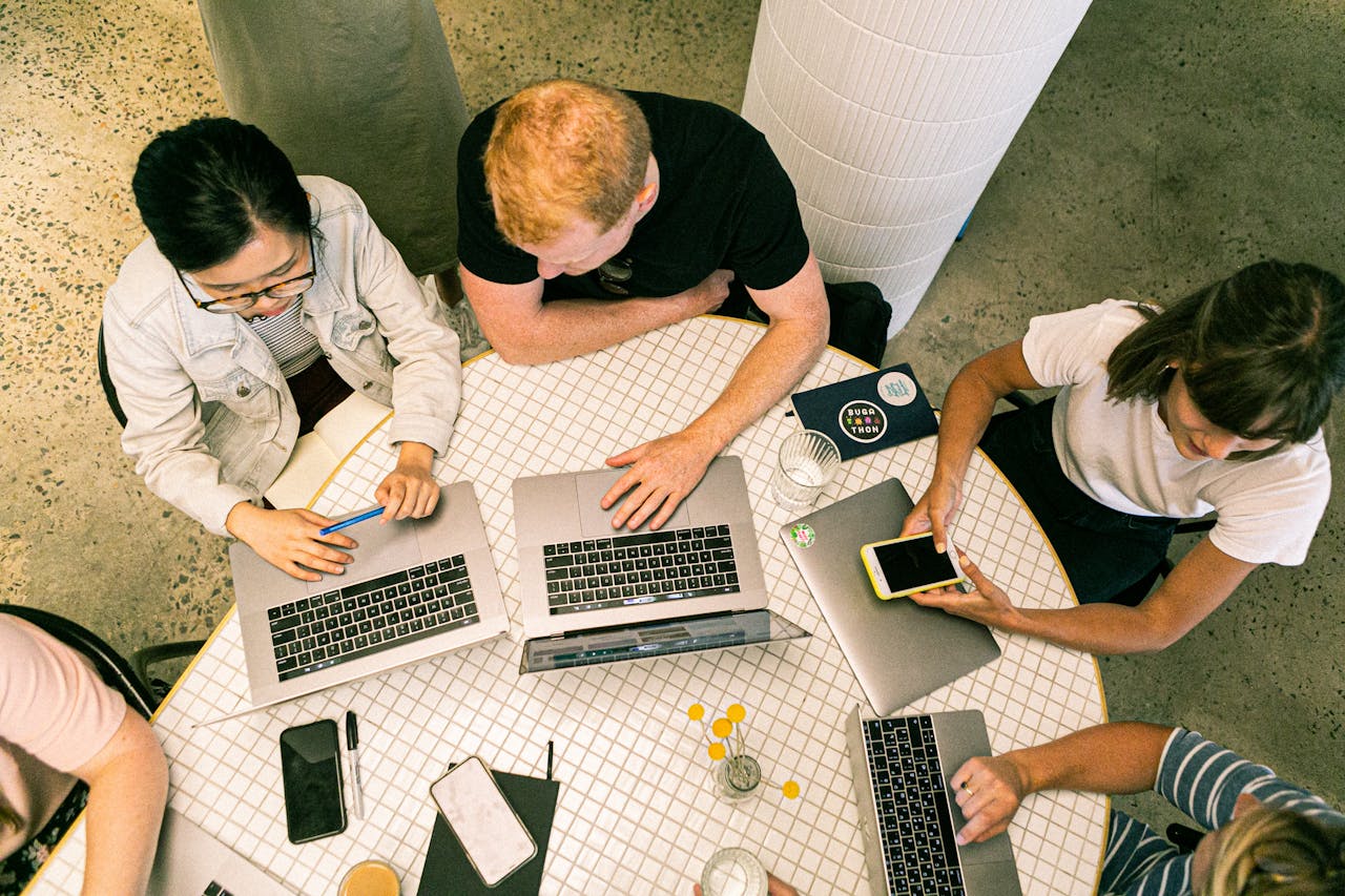 heros-img Top view of diverse team collaboratively working in a modern office setting.